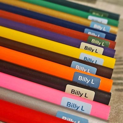 Lápis de cor alinhados, cada um com um mini autocolante com o nome Billy L