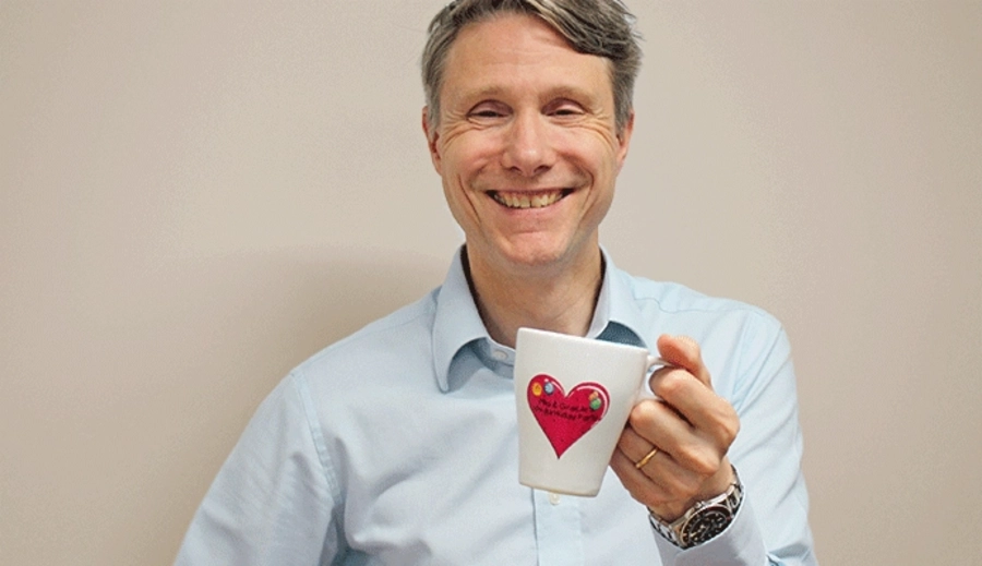 Lars B. Andersen, fundador da My Nametags, a sorrir e a segurar uma caneca